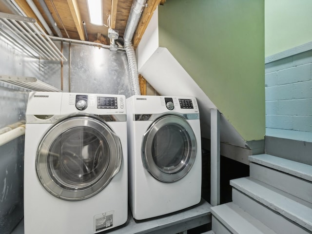 laundry area with laundry area, concrete block wall, and washer and dryer