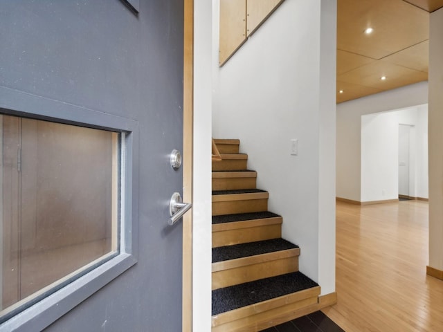 stairway featuring recessed lighting, baseboards, and wood finished floors