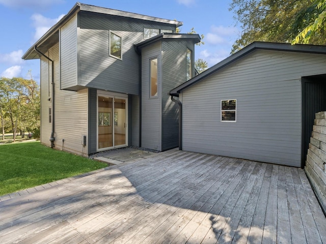 rear view of property featuring a lawn and a deck