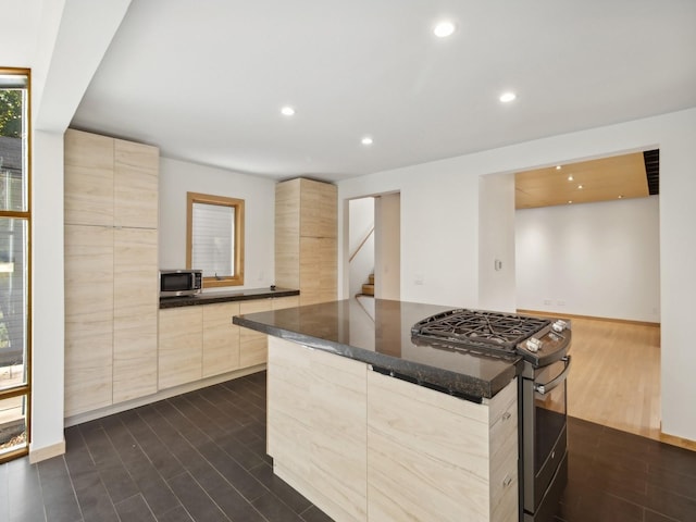 kitchen with light brown cabinetry, appliances with stainless steel finishes, modern cabinets, and dark wood finished floors