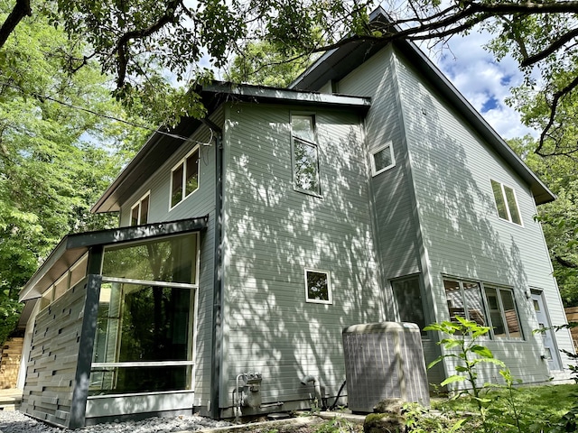 view of side of property featuring central AC unit and a sunroom