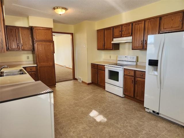 kitchen featuring a textured ceiling, sink, and white appliances