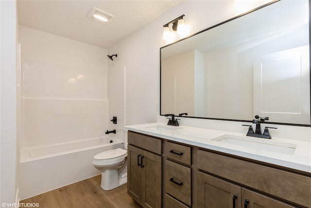 full bathroom with vanity, hardwood / wood-style floors, toilet, and shower / bathtub combination