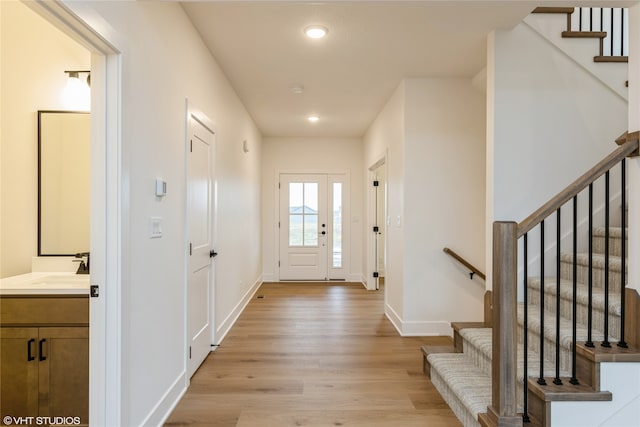 entryway with light wood-style floors, stairs, baseboards, and recessed lighting