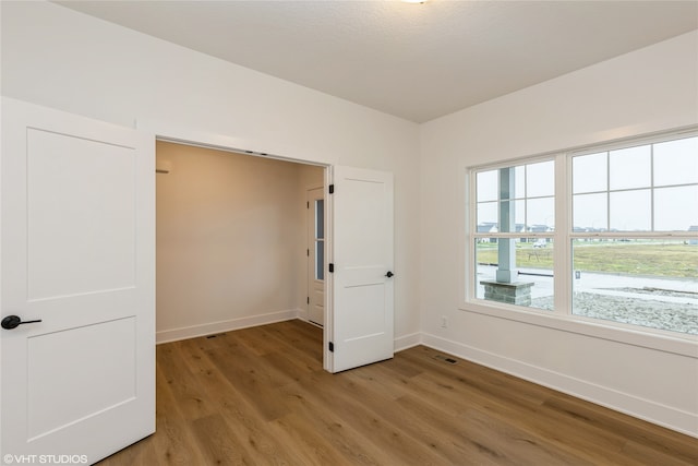 unfurnished room with wood-type flooring