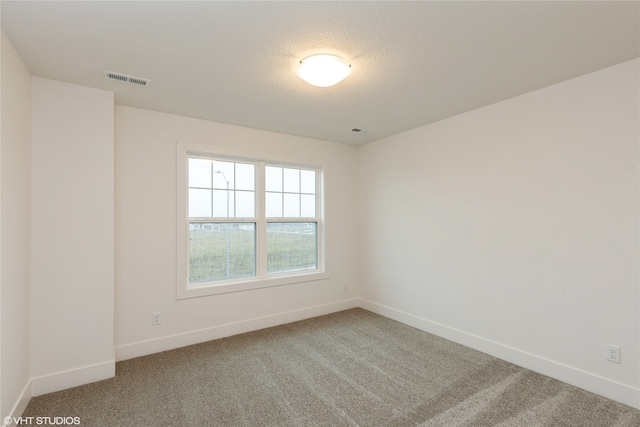 unfurnished room with a textured ceiling and carpet flooring