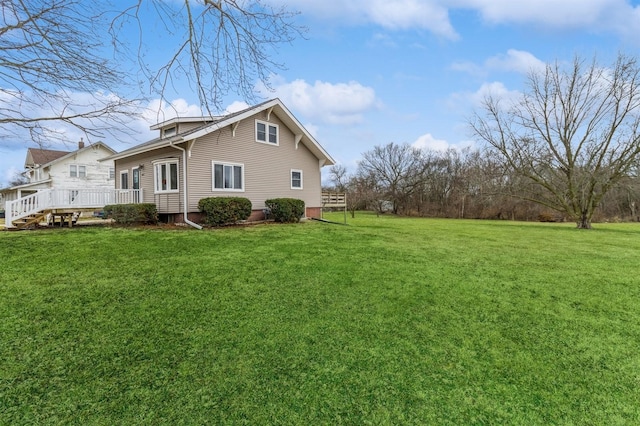 view of side of property featuring a deck and a yard