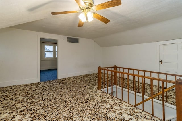 bonus room featuring a textured ceiling, ceiling fan, carpet floors, and vaulted ceiling