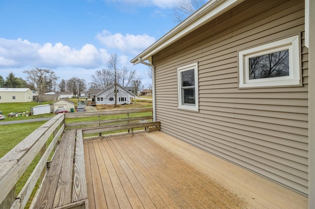 wooden terrace featuring a lawn