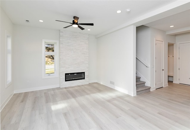 unfurnished living room featuring light hardwood / wood-style flooring, a fireplace, and ceiling fan