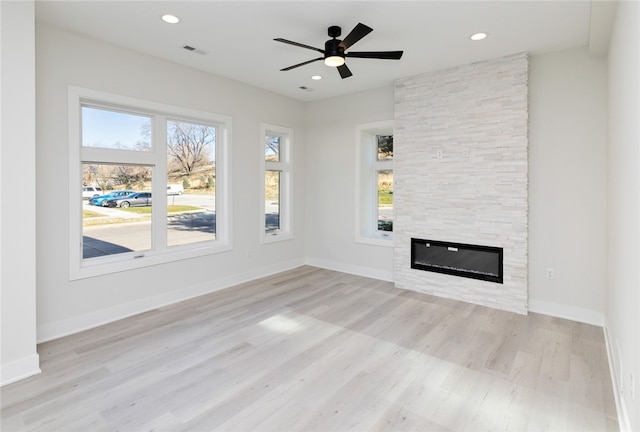 unfurnished living room featuring light hardwood / wood-style floors, a fireplace, and ceiling fan