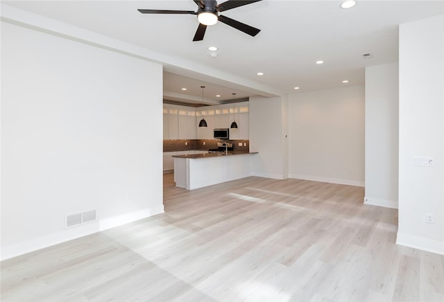 unfurnished living room featuring light hardwood / wood-style flooring and ceiling fan