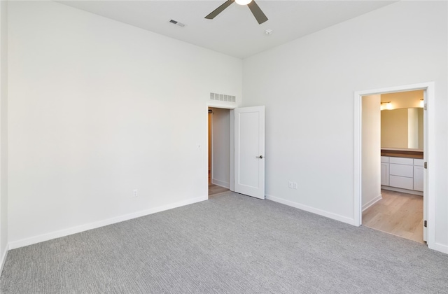 unfurnished bedroom featuring a high ceiling, light carpet, and ceiling fan