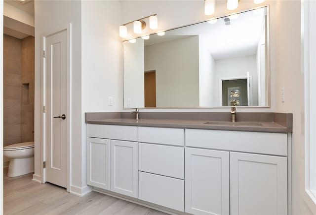 bathroom featuring vanity, hardwood / wood-style floors, and toilet