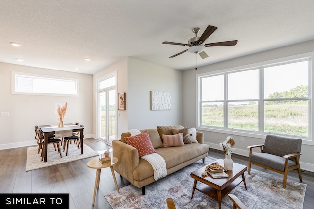 living room with wood-type flooring, a healthy amount of sunlight, and ceiling fan