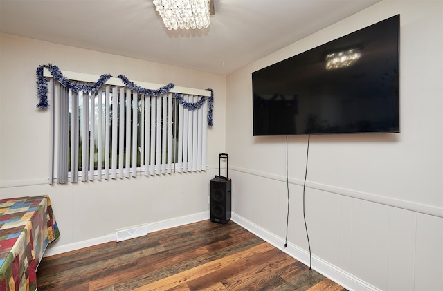 bedroom with dark hardwood / wood-style flooring and an inviting chandelier