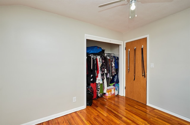 unfurnished bedroom with a closet, hardwood / wood-style floors, a textured ceiling, and ceiling fan