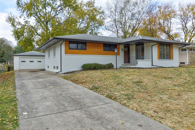 single story home featuring an outbuilding, a front lawn, and a garage