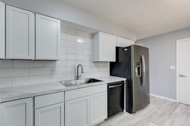 kitchen featuring white cabinets, a sink, dishwasher, stainless steel fridge with ice dispenser, and backsplash