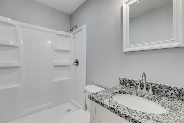 bathroom with toilet, a textured ceiling, vanity, and a shower