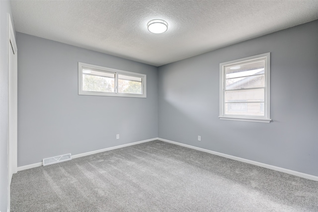 unfurnished room featuring carpet floors and a textured ceiling