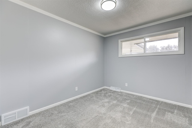 carpeted empty room featuring baseboards, visible vents, a textured ceiling, and crown molding