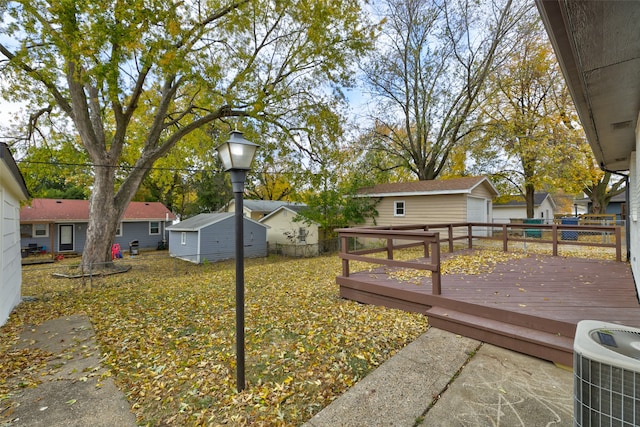 view of yard with a wooden deck, central AC, and an outdoor structure