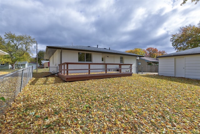 back of house featuring a yard, a deck, and a shed