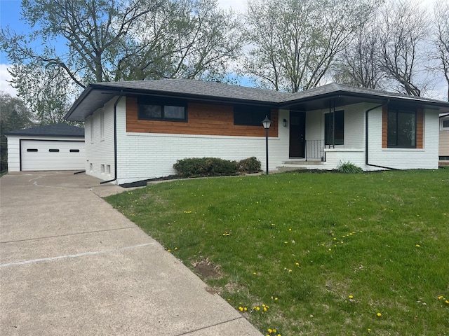view of front facade featuring an outdoor structure, a front lawn, brick siding, and a garage