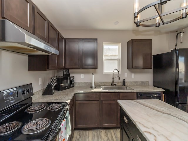 kitchen featuring dark brown cabinetry, a sink, under cabinet range hood, and black appliances