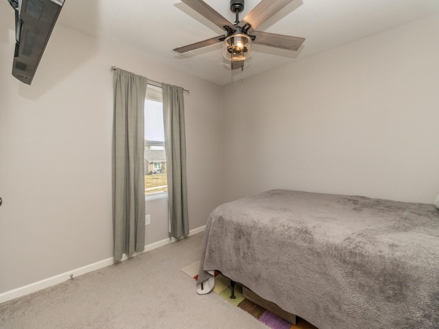 bedroom with ceiling fan, baseboards, and light colored carpet