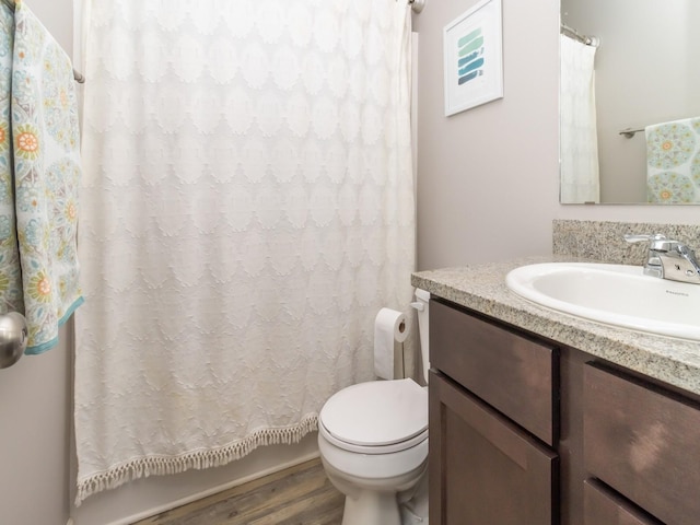 bathroom featuring a shower with curtain, vanity, toilet, and wood finished floors