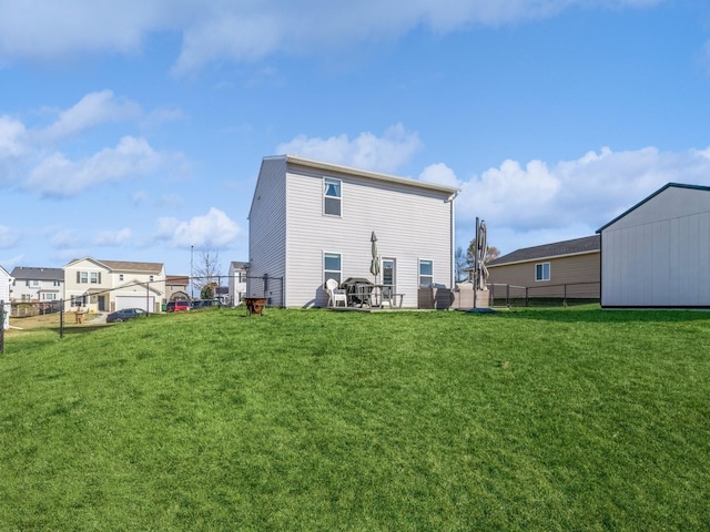 back of house with fence and a lawn