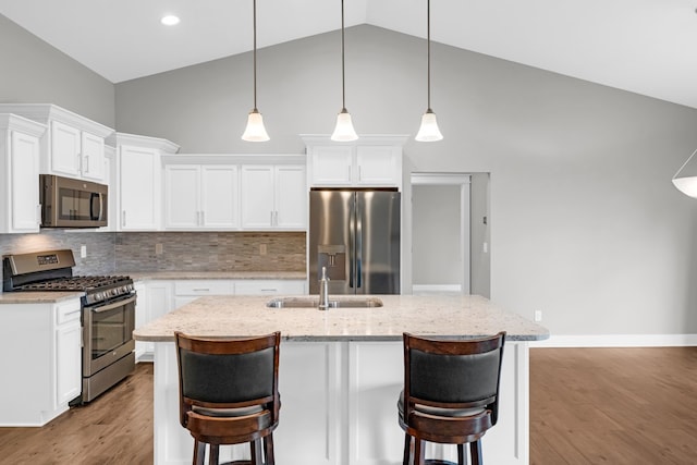 kitchen with appliances with stainless steel finishes, light hardwood / wood-style flooring, and white cabinetry