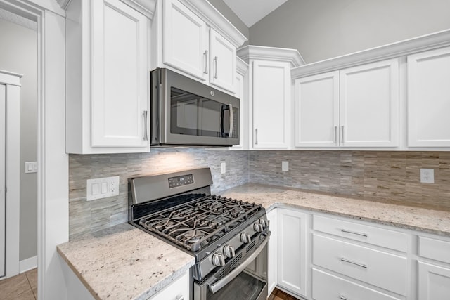 kitchen with white cabinets, stainless steel appliances, and backsplash