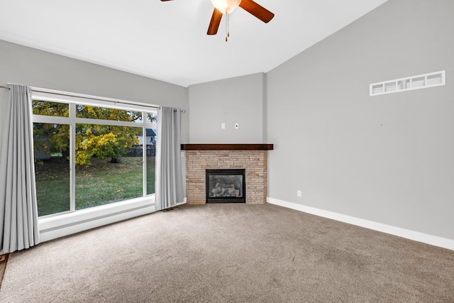 unfurnished living room featuring ceiling fan, carpet flooring, and a brick fireplace