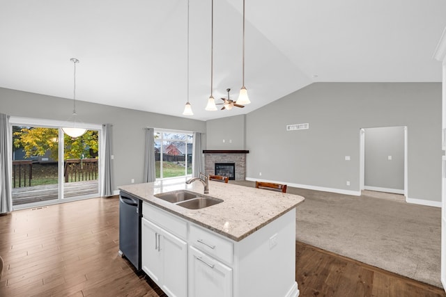 kitchen featuring white cabinetry, stainless steel dishwasher, vaulted ceiling, pendant lighting, and sink