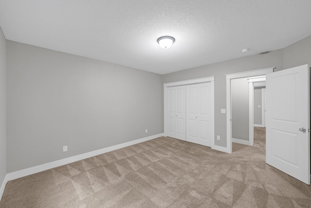 unfurnished bedroom with light carpet and a textured ceiling