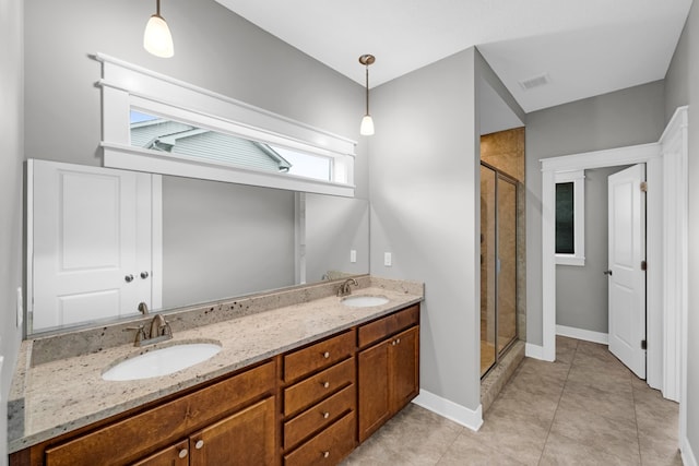 bathroom featuring a shower with door, vanity, and tile patterned flooring