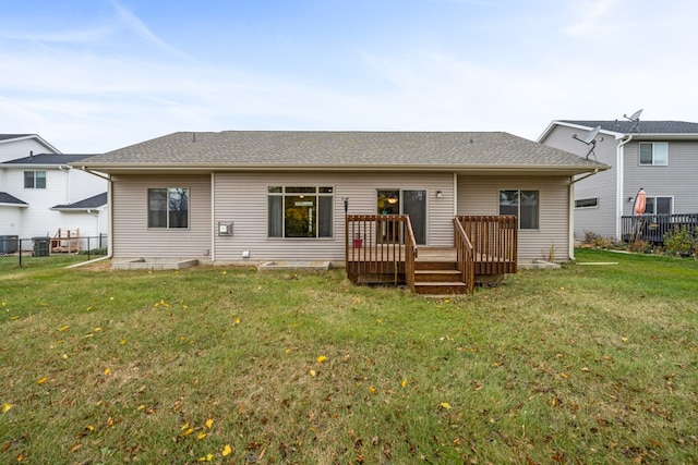 rear view of house featuring a wooden deck, cooling unit, and a yard