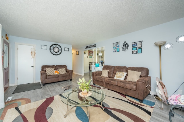 living room featuring a textured ceiling and light wood-type flooring