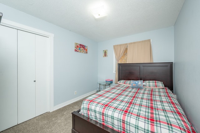 bedroom with a closet, carpet flooring, and a textured ceiling