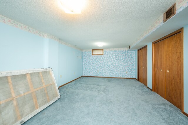 interior space with light carpet and a textured ceiling