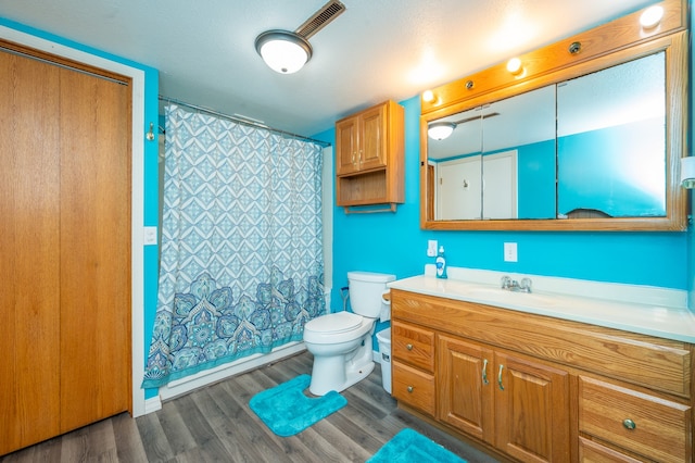 bathroom featuring vanity, hardwood / wood-style floors, toilet, and walk in shower