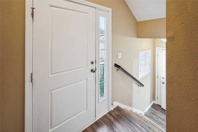 foyer with hardwood / wood-style flooring and vaulted ceiling