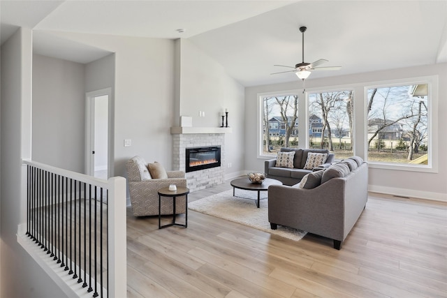 living room with ceiling fan, light hardwood / wood-style floors, and lofted ceiling