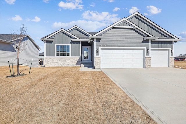 craftsman house featuring driveway, stone siding, board and batten siding, and an attached garage