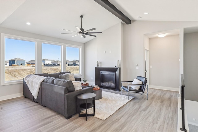 living room featuring vaulted ceiling with beams, light wood-style flooring, baseboards, and a wealth of natural light