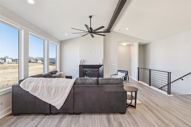 living area featuring a fireplace, vaulted ceiling with beams, recessed lighting, light wood-style floors, and baseboards