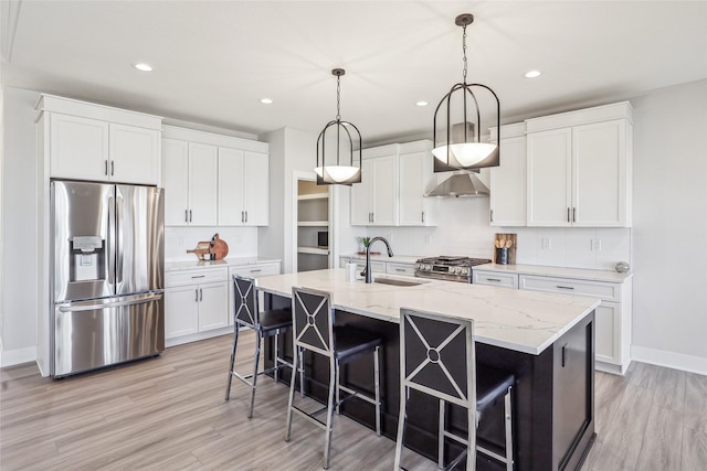 kitchen featuring a center island with sink, appliances with stainless steel finishes, white cabinets, and a sink